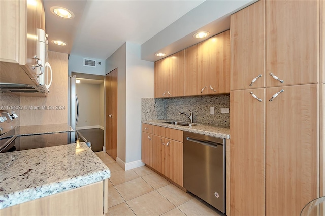 kitchen featuring light stone countertops, sink, light tile patterned floors, and appliances with stainless steel finishes