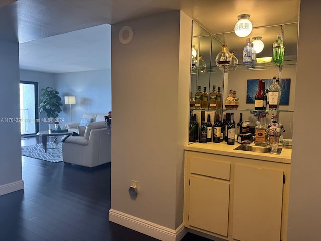 bar featuring dark hardwood / wood-style floors and sink