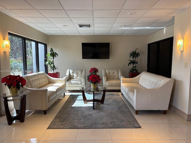 tiled living room featuring a drop ceiling