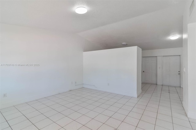 unfurnished room with light tile patterned floors and a textured ceiling