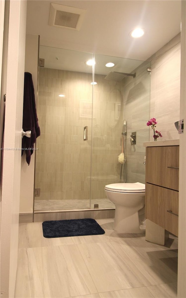 bathroom with toilet, walk in shower, and tile walls