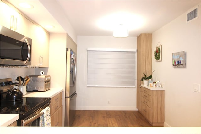 kitchen with light wood-type flooring and appliances with stainless steel finishes