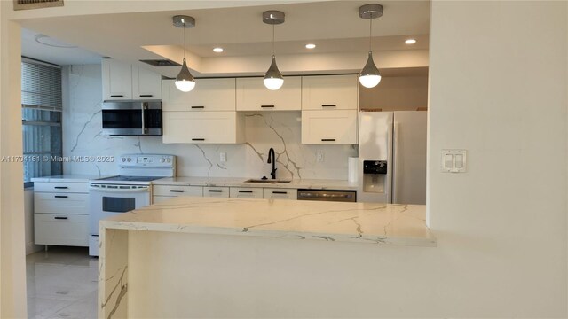 kitchen with decorative backsplash, appliances with stainless steel finishes, light stone countertops, sink, and white cabinets