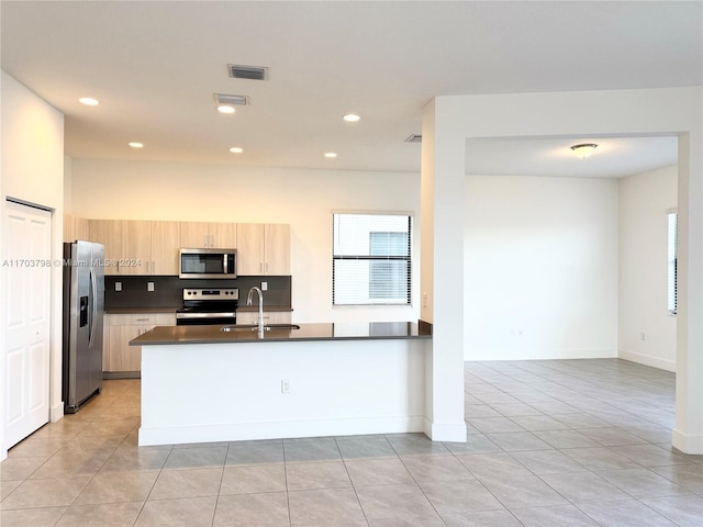 kitchen featuring sink, light tile patterned floors, light brown cabinetry, appliances with stainless steel finishes, and kitchen peninsula