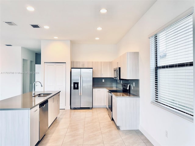 kitchen with sink, light tile patterned floors, and stainless steel appliances