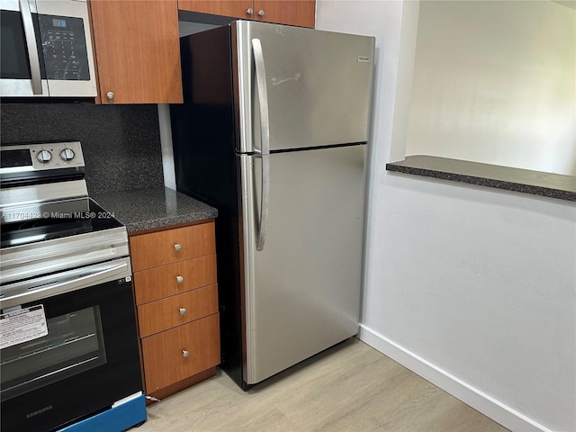 kitchen featuring stainless steel appliances, tasteful backsplash, and light hardwood / wood-style floors