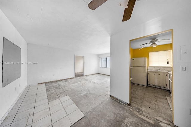 unfurnished living room with ceiling fan and sink