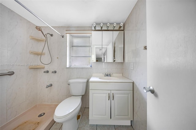 bathroom with vanity, tile patterned floors, toilet, tiled shower, and tile walls