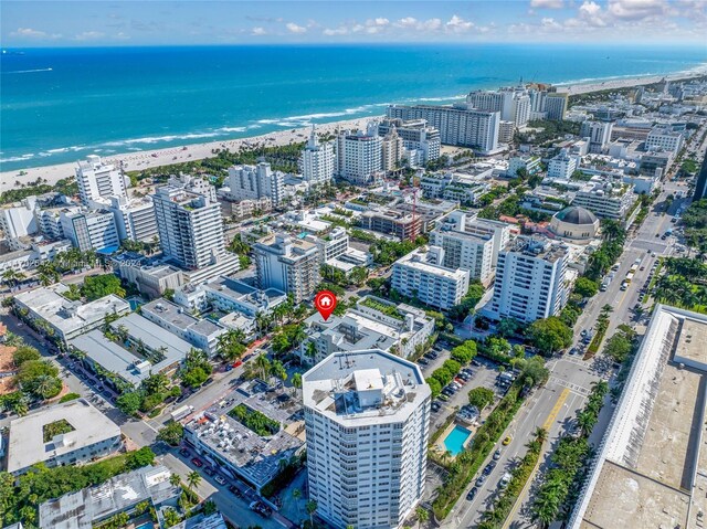 drone / aerial view with a beach view and a water view