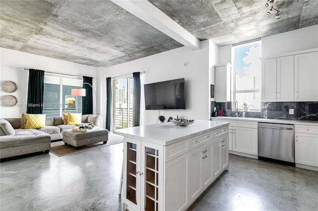 kitchen featuring a center island, white cabinetry, decorative backsplash, sink, and stainless steel dishwasher