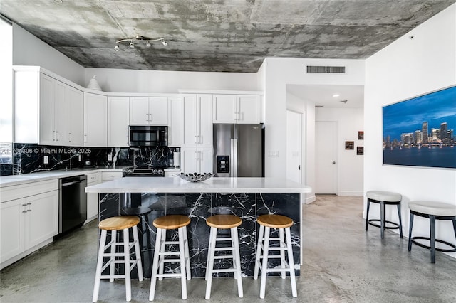 kitchen featuring dishwashing machine, a center island, stainless steel refrigerator with ice dispenser, decorative backsplash, and white cabinets