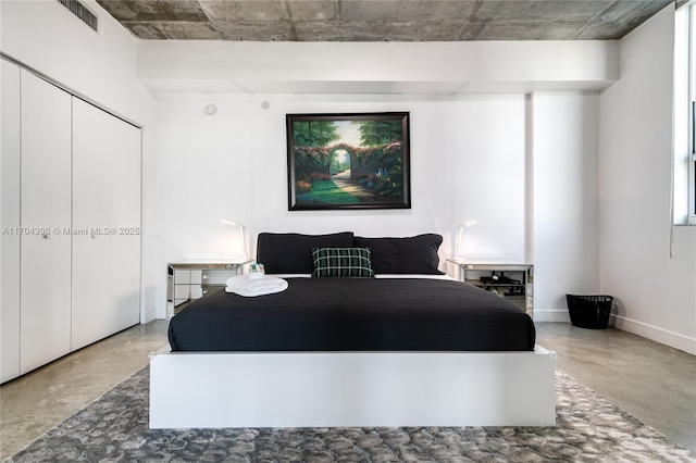 bedroom with a closet and concrete flooring