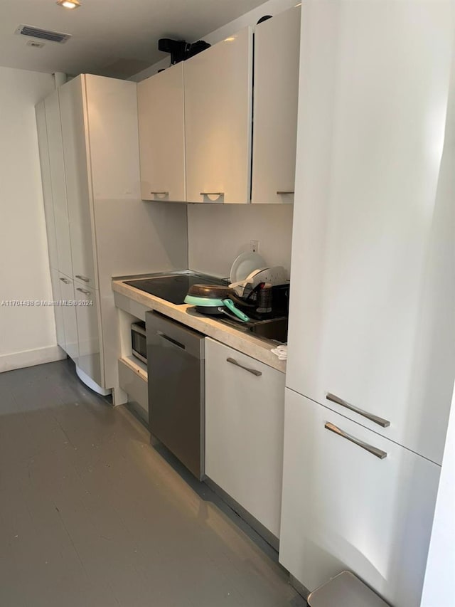 kitchen featuring dishwasher, white fridge, and white cabinetry