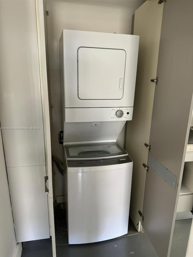 clothes washing area featuring stacked washer and clothes dryer