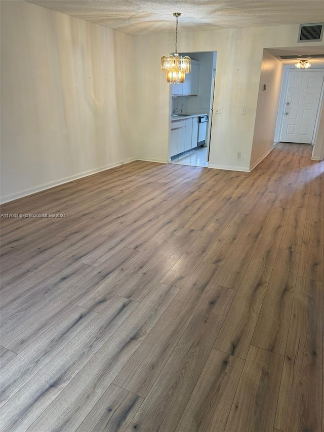 interior space featuring hardwood / wood-style floors, sink, a textured ceiling, and a chandelier