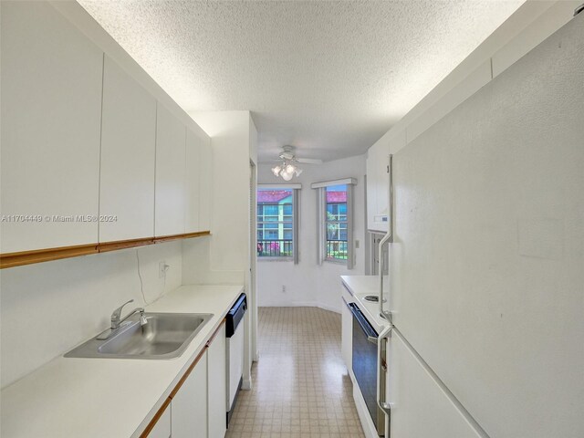 kitchen featuring a textured ceiling, white appliances, ceiling fan, sink, and white cabinetry