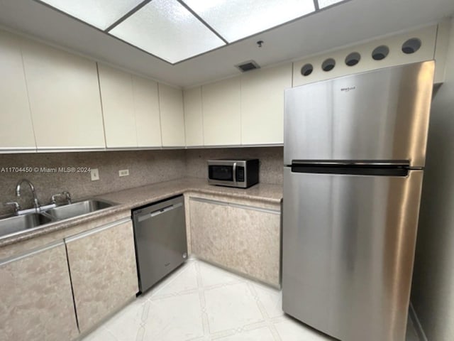 kitchen featuring stainless steel appliances, tasteful backsplash, and sink