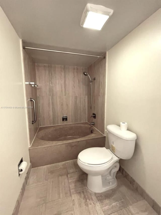 bathroom with toilet and tiled shower / bath