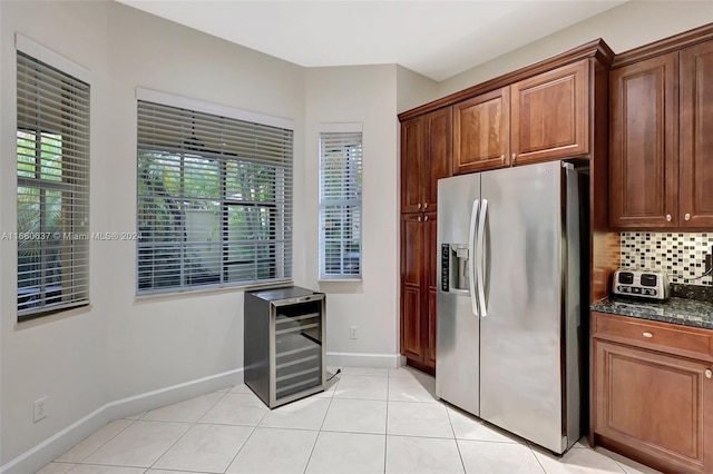 kitchen with dark stone counters, wine cooler, decorative backsplash, stainless steel fridge, and light tile patterned floors