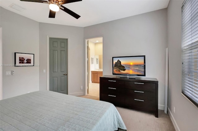 bedroom featuring light carpet, connected bathroom, and ceiling fan