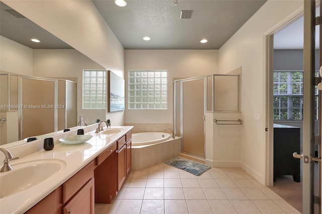 bathroom featuring plus walk in shower, a textured ceiling, vanity, and tile patterned floors