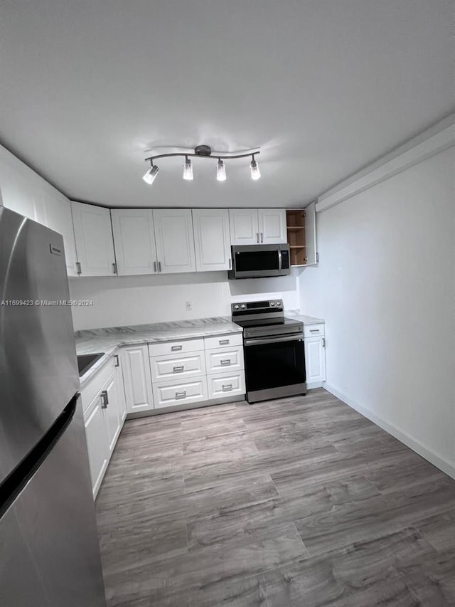 kitchen featuring light hardwood / wood-style floors, white cabinetry, and appliances with stainless steel finishes