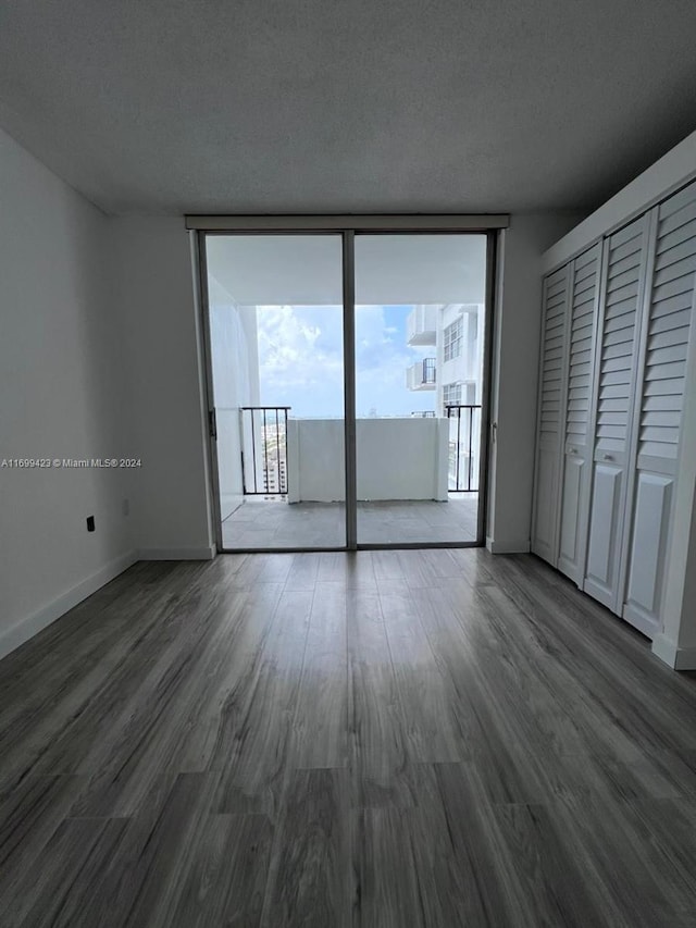 interior space featuring access to exterior, hardwood / wood-style floors, a textured ceiling, and multiple windows