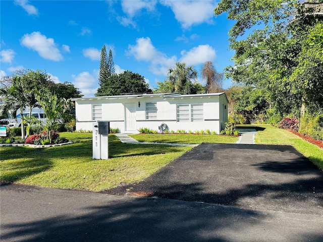 manufactured / mobile home with stucco siding and a front yard