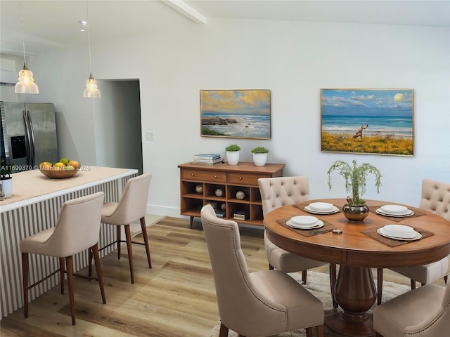 dining area featuring beam ceiling and light wood-type flooring