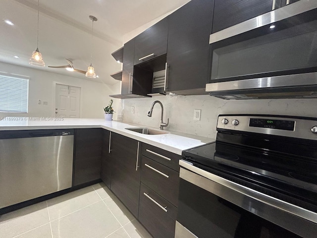 kitchen featuring light tile patterned flooring, sink, pendant lighting, stainless steel appliances, and decorative backsplash