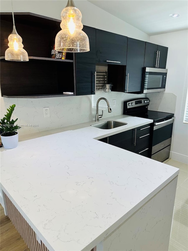 kitchen with pendant lighting, sink, lofted ceiling, appliances with stainless steel finishes, and decorative backsplash