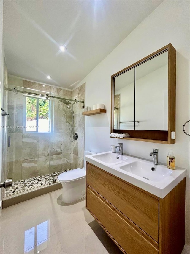 bathroom featuring vanity, toilet, and a shower with door