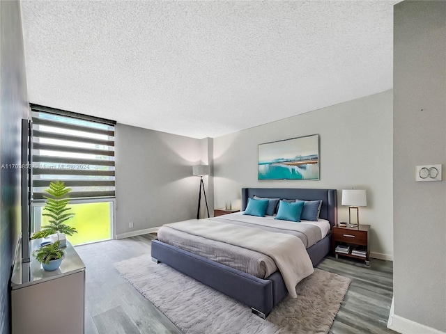 bedroom with hardwood / wood-style floors and a textured ceiling