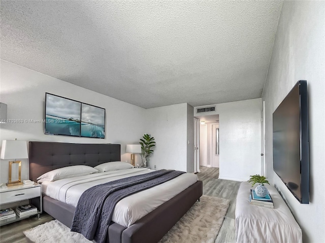 bedroom featuring hardwood / wood-style floors and a textured ceiling