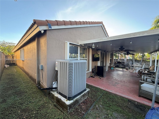 view of side of property featuring cooling unit, a patio area, and ceiling fan