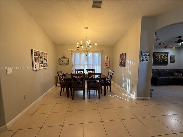 tiled dining area featuring ceiling fan with notable chandelier and vaulted ceiling