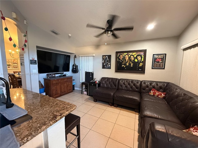 living room with ceiling fan, light tile patterned floors, and lofted ceiling