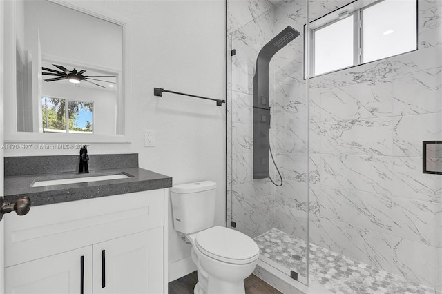 bathroom featuring vanity, toilet, plenty of natural light, and ceiling fan