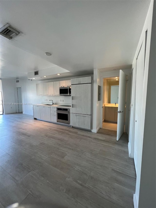 kitchen with sink, wood-type flooring, and appliances with stainless steel finishes