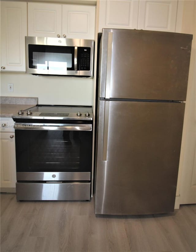 kitchen featuring white cabinets, light hardwood / wood-style floors, and appliances with stainless steel finishes