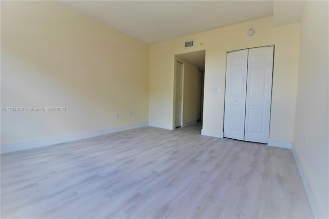 unfurnished bedroom featuring a closet and light hardwood / wood-style flooring