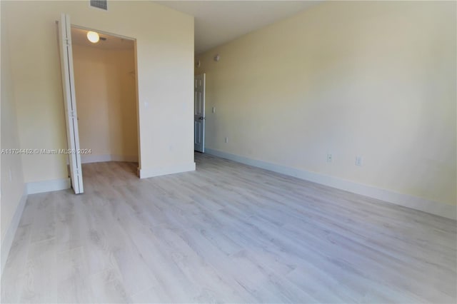 unfurnished bedroom featuring a closet and light wood-type flooring