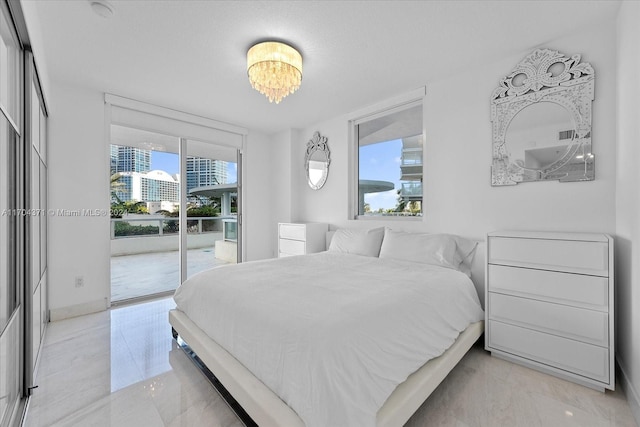 bedroom with access to outside and a notable chandelier