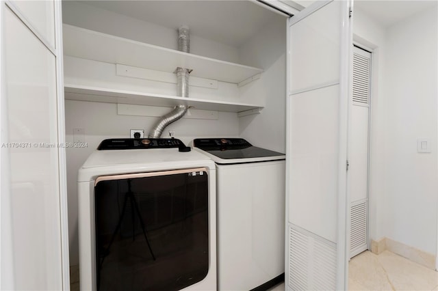 washroom featuring washer and clothes dryer and light tile patterned floors