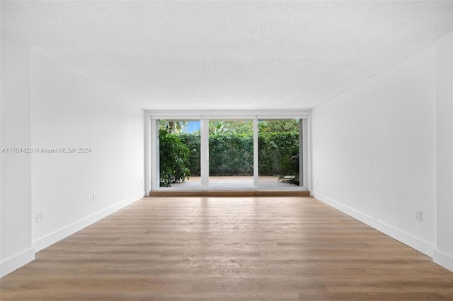 spare room with light hardwood / wood-style flooring and a textured ceiling