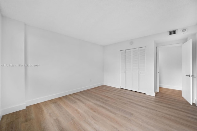 unfurnished bedroom with a closet and light hardwood / wood-style flooring