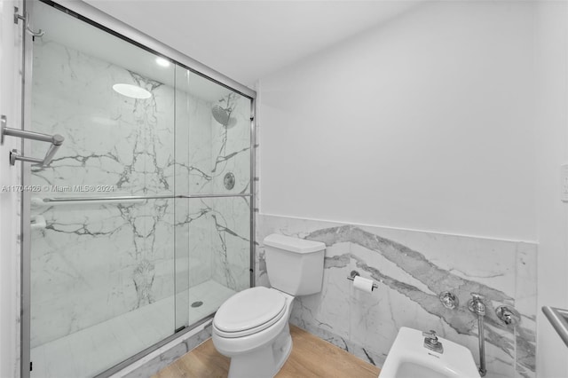 bathroom featuring a bidet, wood-type flooring, toilet, a shower with door, and tile walls