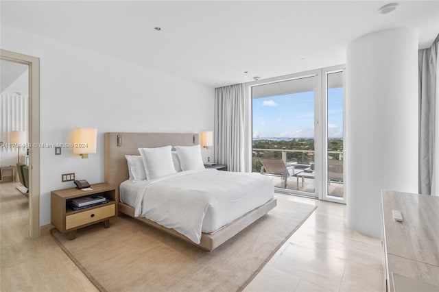 bedroom with access to outside and a wall of windows