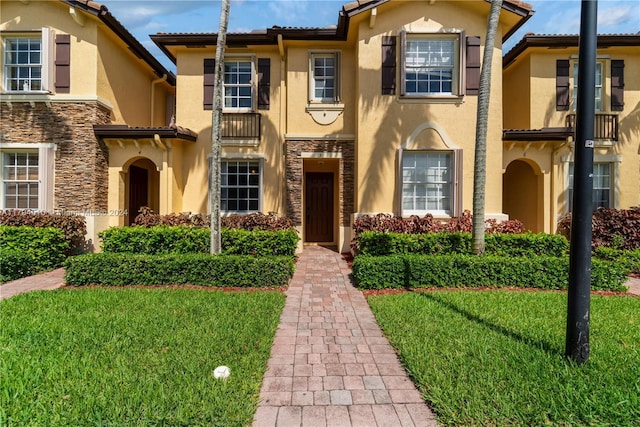 mediterranean / spanish home with a front yard