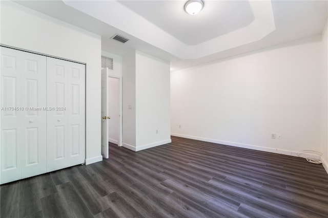 unfurnished bedroom featuring dark hardwood / wood-style flooring and a closet